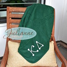 a green towel sitting on top of a wooden chair