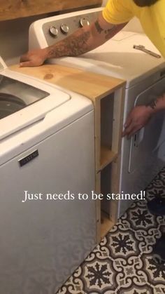 a man standing next to a washer and dryer