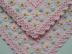 three crocheted baby blankets with flowers on them