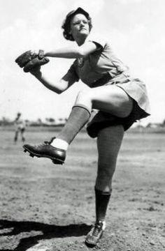 an old black and white photo of a woman pitching a ball in a baseball field