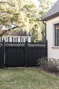 a black fence in front of a white house