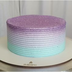 a purple and blue cake sitting on top of a white plate