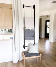 a chair sitting on top of a hard wood floor in front of a window with white drapes