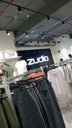 men's clothing on display in a store with the name zudio hanging above them