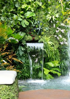 a water fountain surrounded by greenery and flowers