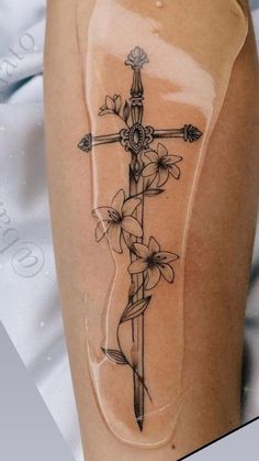 a cross with flowers on it and a ribbon around the leg is shown in black ink