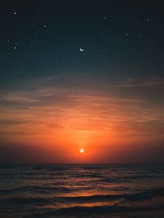 the sun is setting over the ocean with stars in the sky