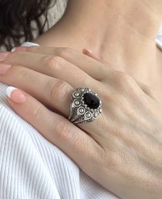 Experience the beauty of handcrafted jewelry with this exquisite embroidery ring. Made with the highest quality materials, the 925 sterling silver band is designed with filigree art and oxidized for an antique look. The 10x12 mm cabochon oval cut Black Onyx gemstone is set in a bezel setting, adding a touch of luxury and sophistication to any outfit. Measuring 0.9 inches / 22.50 mm in length and 0.80 inches / 20.00 mm in width, this ring features intricate filigree details that showcase the arti Luxury Sterling Silver Gemstone Dome Ring, Traditional Black Filigree Jewelry, Black Oval Filigree Jewelry, Vintage Round Filigree Ring With Oxidized Finish, Oval Black Filigree Jewelry, Black Filigree Ring Jewelry, Black Ring With Intricate Design, Black Filigree Ring, Oxidized Finish Filigree Ring For Gift