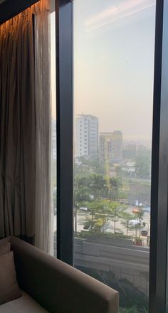 a couch sitting in front of a window overlooking a city