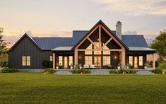 a house with a large front porch and two windows on each side, surrounded by green grass