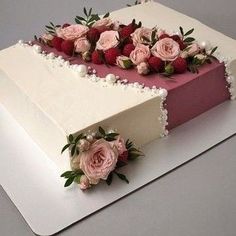 a large white and pink cake with flowers on top