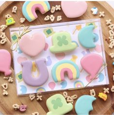 some cookies are sitting on a plate with rainbows and clouds in the shape of letters