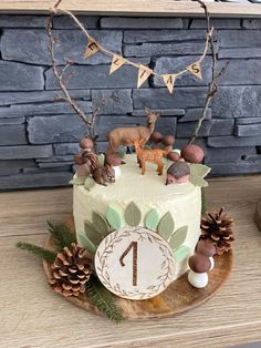 a birthday cake decorated with animals and pine cones