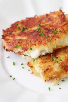 two crab cakes on a white plate with parsley sprinkled around the edges