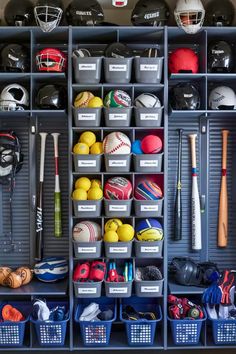 an organized baseball locker with balls, bats and other sports equipment in bins on the wall