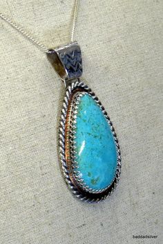 Massive, light blue-green Kingman. "Ocean View with Floating Cloud."  Sterling silver Filigree bezel with copper accent and then, heavy sterling silver rope pattern surround.  For size, color, accent, silver, beauty, this pendant has across the room presence. Totally unique and one of a kind. Blue Teardrop Western Style Jewelry, Blue Sterling Silver Western Jewelry, Blue Western Sterling Silver Jewelry, Western Style Engraved Blue Jewelry, Untreated Blue Western Jewelry, Rope Pattern, Copper Accents, Light Blue Green, Sterling Silver Filigree