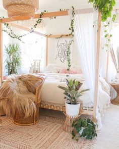 a bed with white sheets and plants on top of it in a room filled with potted plants