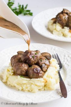 someone pouring gravy over mashed potatoes with meatballs on the top and side