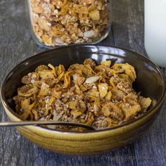 a bowl filled with granola next to a bottle of milk