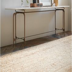 a white table with some plants on it and a mirror in the corner behind it