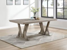 a wooden table sitting on top of a rug in a living room next to a window