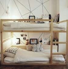 a bunk bed with white sheets and pillows