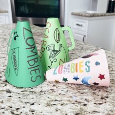 two party hats sitting on top of a kitchen counter next to a paper cone with the word zooress written on it