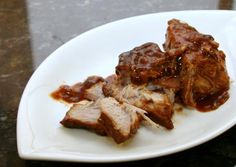 some meat is sitting on a white plate