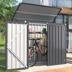 a bike is parked in the side of a shed with its door open to reveal it's storage area