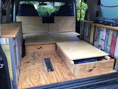 the back end of a van with wooden drawers and storage boxes in it's cargo area