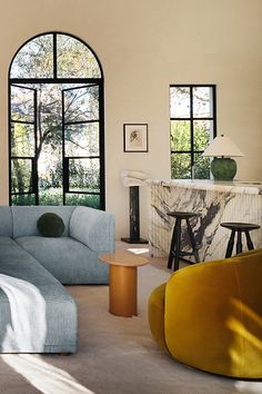 a living room filled with furniture and large windows