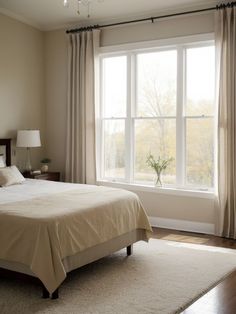 a bedroom with a large bed and two windows