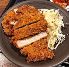 two pieces of fried chicken and noodles on a plate