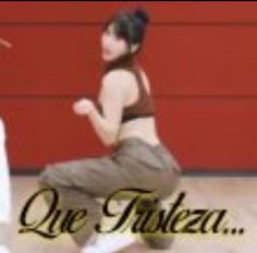 a young woman is dancing in front of a red wall with the words que falesa on it