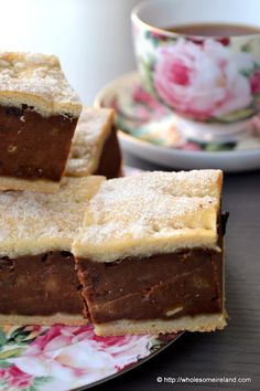 several pieces of cake sitting on top of a plate next to a cup and saucer