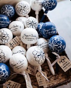 a basket filled with blue and white decorated lollipops on top of a table