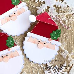 three santa claus ornaments on top of a doily with snowflakes in the background