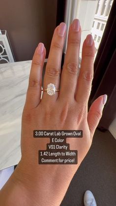 a woman's hand with an engagement ring on it and the price label below