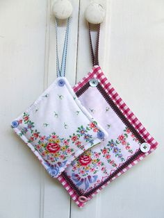 two pieces of cloth hanging on a white door with wooden handles and knobs in the shape of flowers