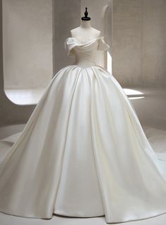 a white wedding dress on display in a room