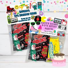 two bags of candy with stickers on them and a birthday cake in the background