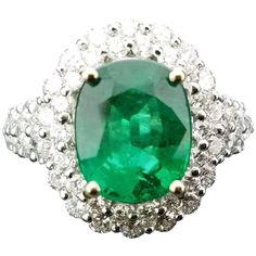 an emerald and diamond ring on a white background