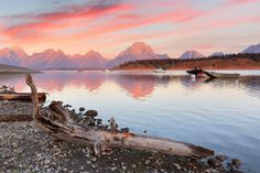 there is a boat on the water and mountains in the backgrounnds