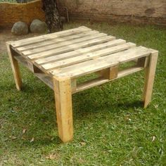 a wooden table sitting on top of green grass