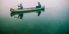 two people in a canoe paddling on the water