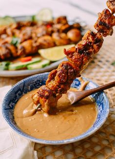 the skewer is being dipped with sauce