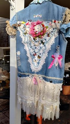 an old jean jacket with lace and flowers on it