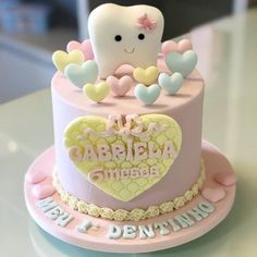 a pink cake with a tooth and hearts on it