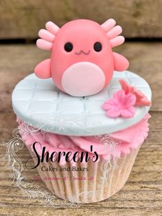 there is a cupcake with pink frosting on it and a stuffed animal in the middle