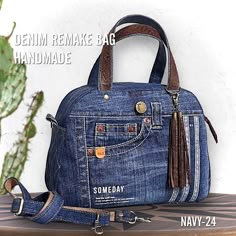 a denim bag with tassels on it sitting on top of a wooden table